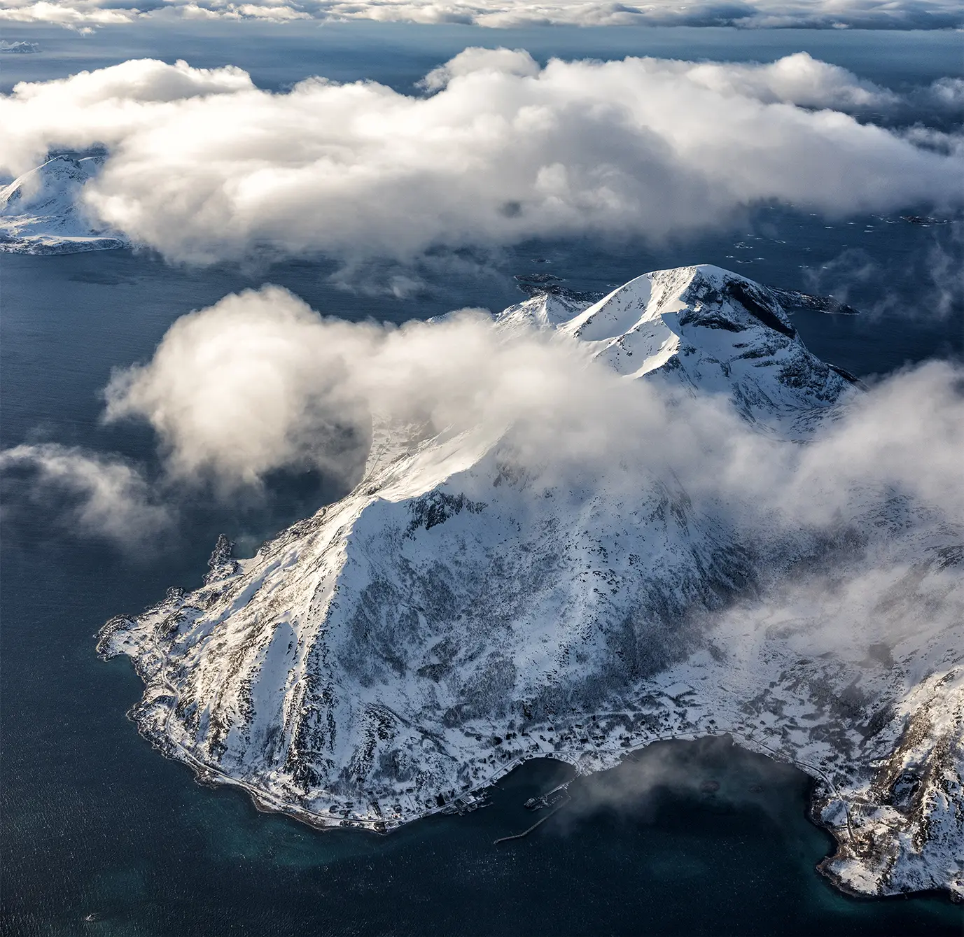 View through clouds to mountain in Arctic Ocean