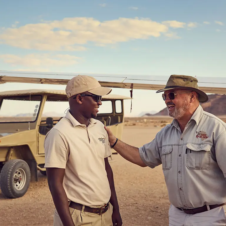 Two men talking in front of off-road vehicle