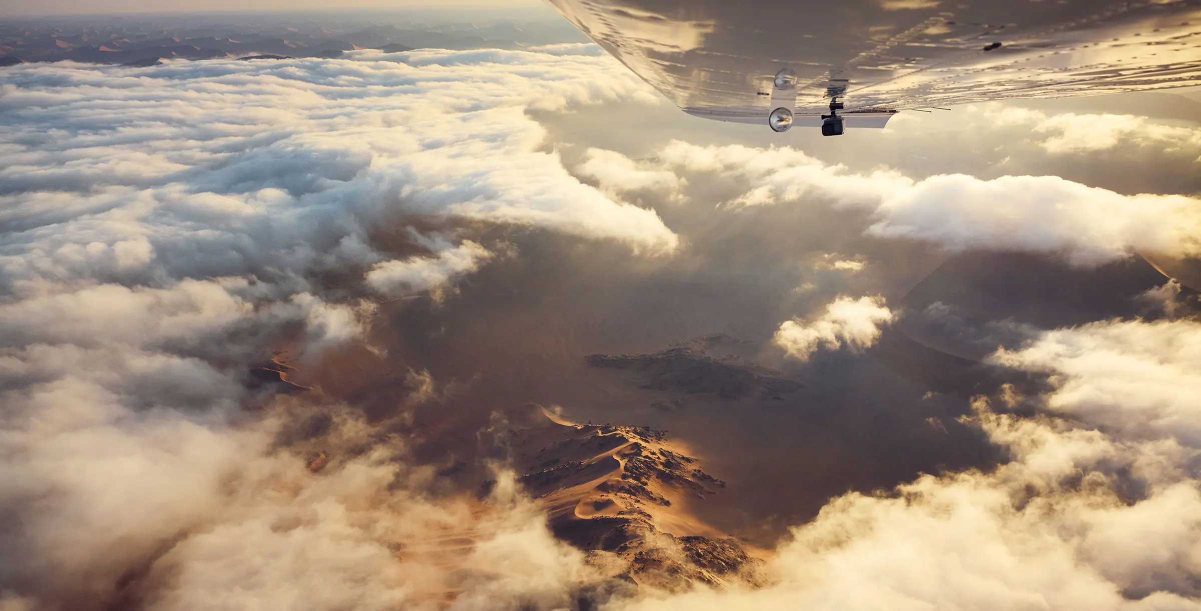 View over wings into clouds and desert