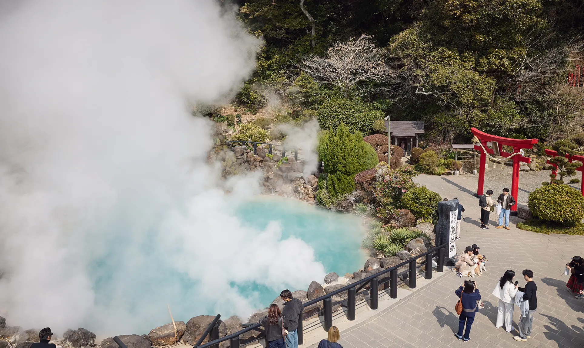 Group of people at a steaming thermal spring – fascinating natural attraction in Japan
