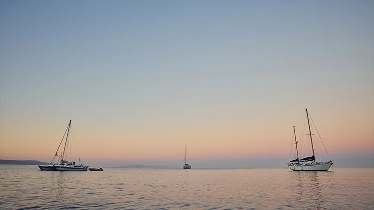 Segelboote liegen im Wasser in Morgenröte
