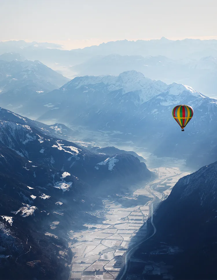 Hot air balloon floating over the Alps